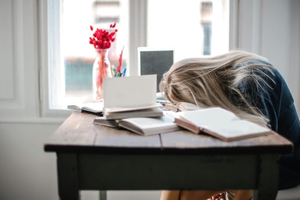 Exhausted Woman Leaning on Table Anti Hustle Culture