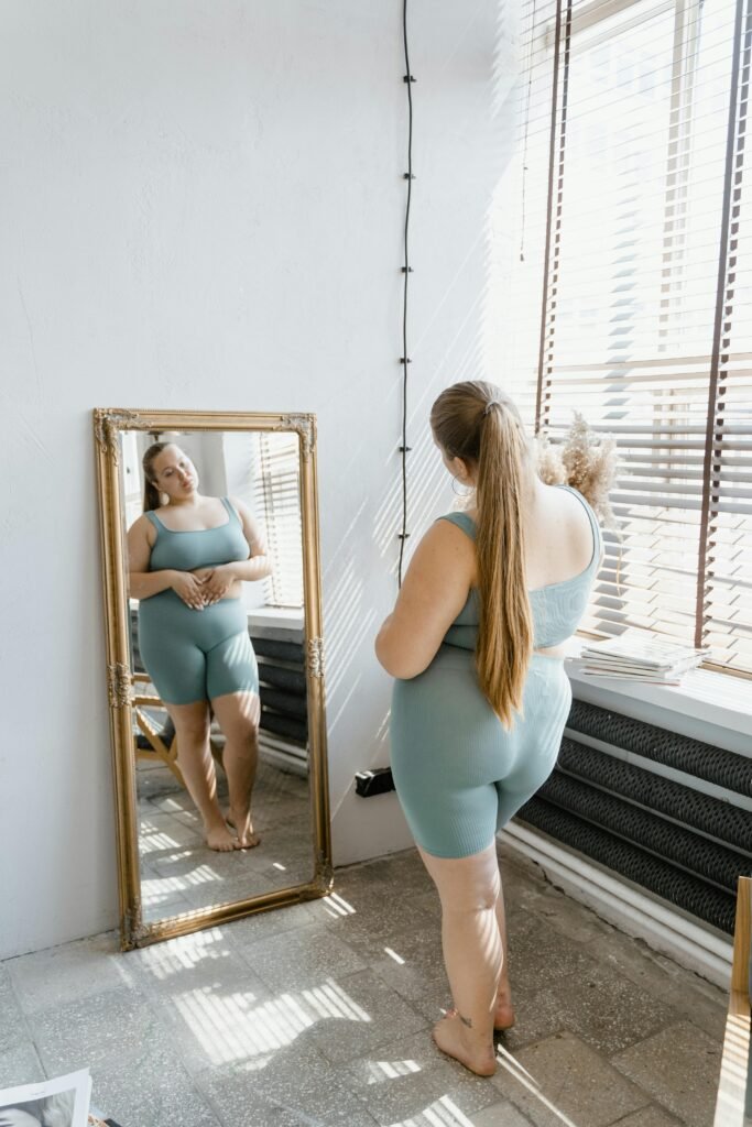 A Millennial Woman Looking at the Mirror Saying Positive Body Image Affirmations